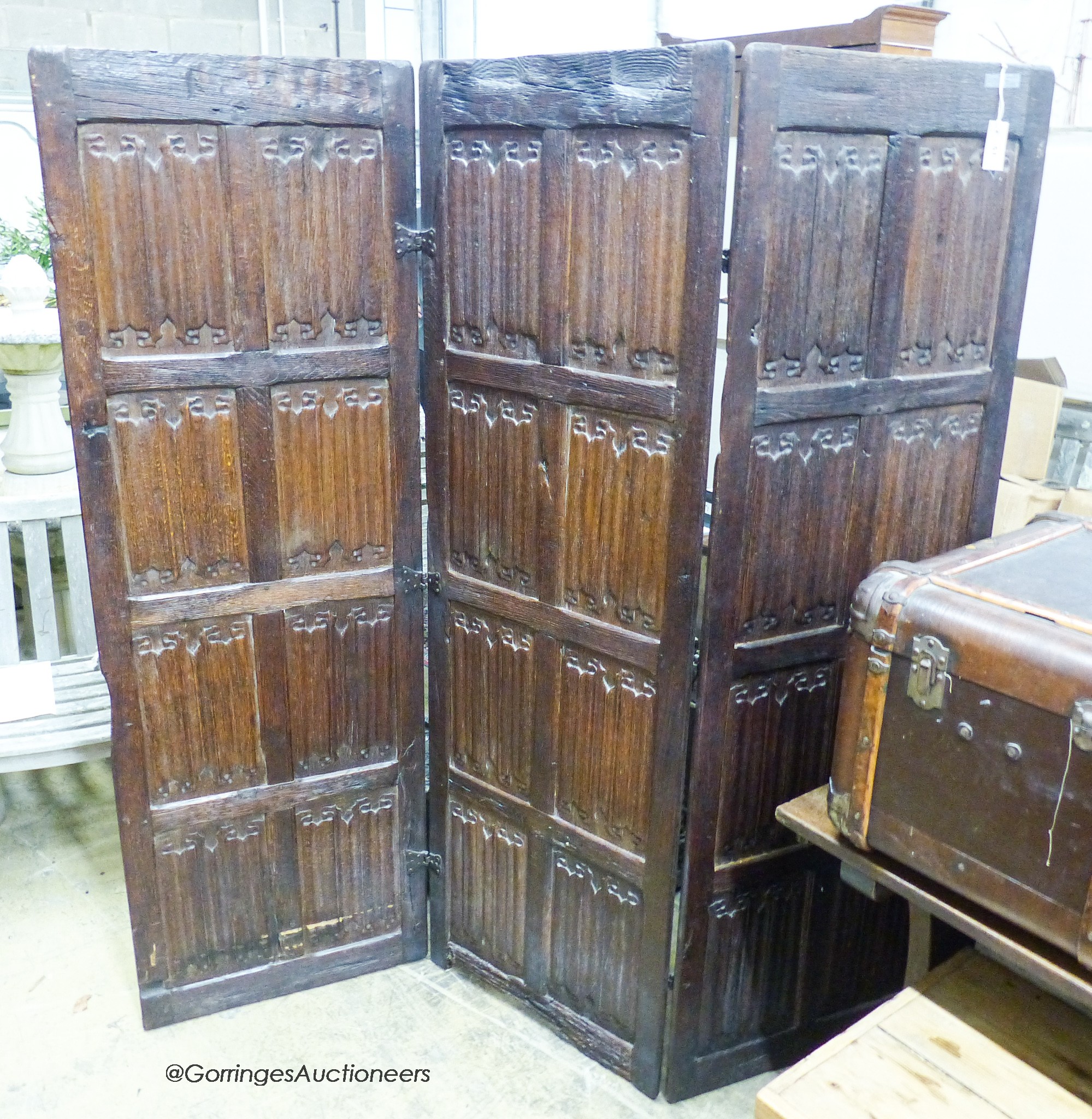 An oak three-fold screen incorporating twenty-four 16th / 17th century linenfold-carved panels, each panel width 59cm, height 182cm